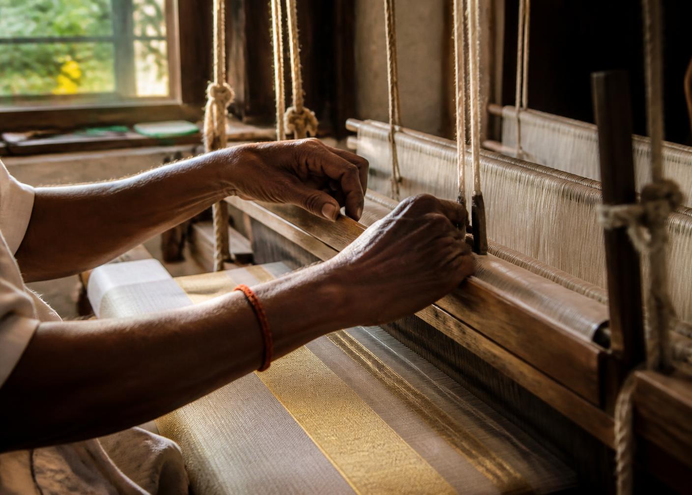 Weaver working at a traditional wooden pit loom